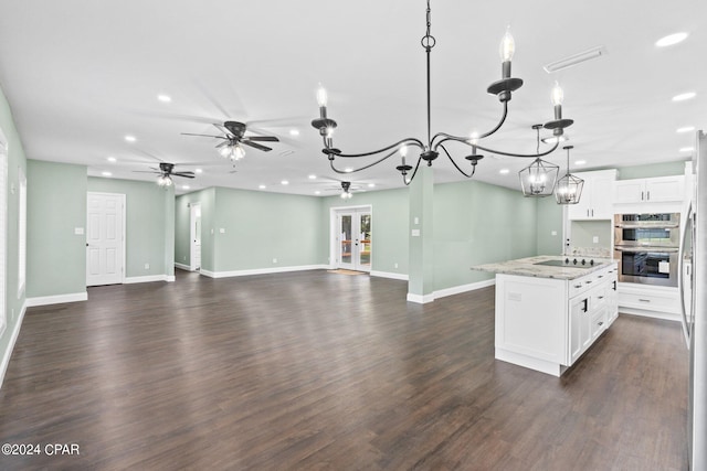 kitchen with white cabinetry, hanging light fixtures, light stone counters, dark hardwood / wood-style flooring, and a center island with sink