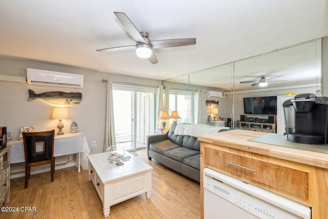 living room featuring ceiling fan, a wall mounted AC, and light wood-type flooring