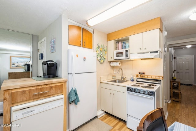 kitchen featuring under cabinet range hood, white appliances, a sink, white cabinetry, and light countertops