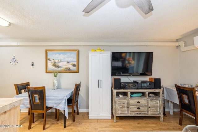 dining room with light wood finished floors, baseboards, and a ceiling fan