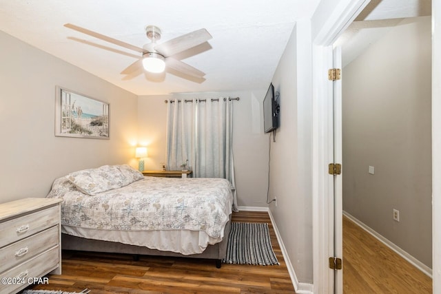 bedroom featuring dark wood-style floors, ceiling fan, and baseboards