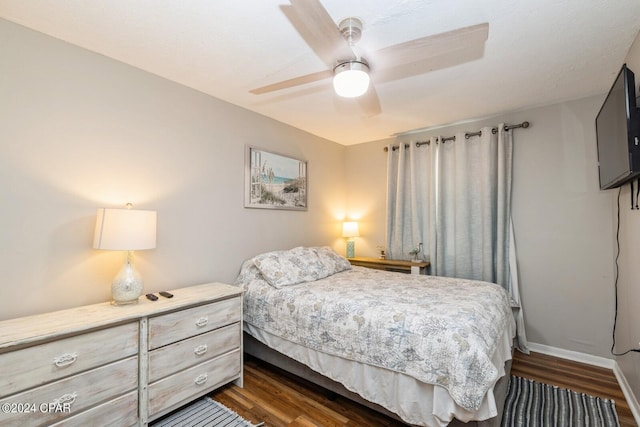 bedroom featuring dark wood-style floors, baseboards, and a ceiling fan