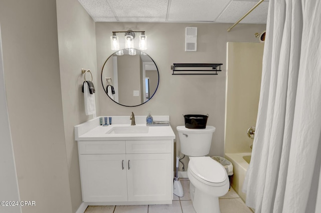 full bathroom with shower / tub combo, vanity, a drop ceiling, tile patterned floors, and toilet