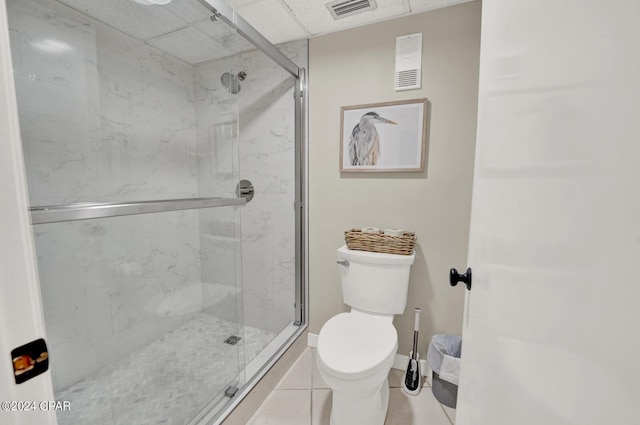 bathroom featuring tile patterned floors, toilet, and a shower with shower door