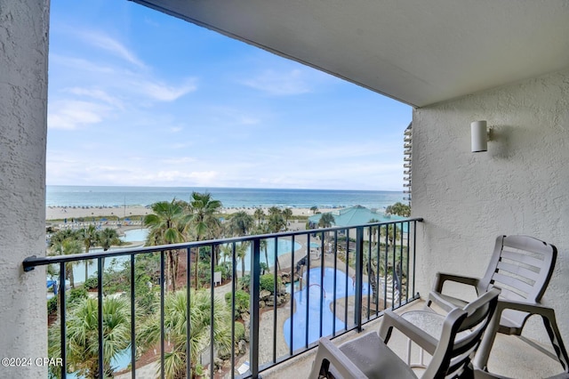 balcony featuring a water view and a beach view