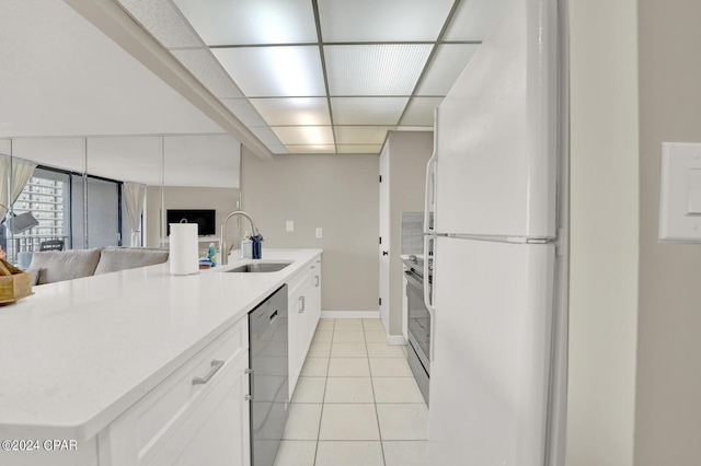 kitchen featuring appliances with stainless steel finishes, sink, light tile patterned floors, and white cabinets