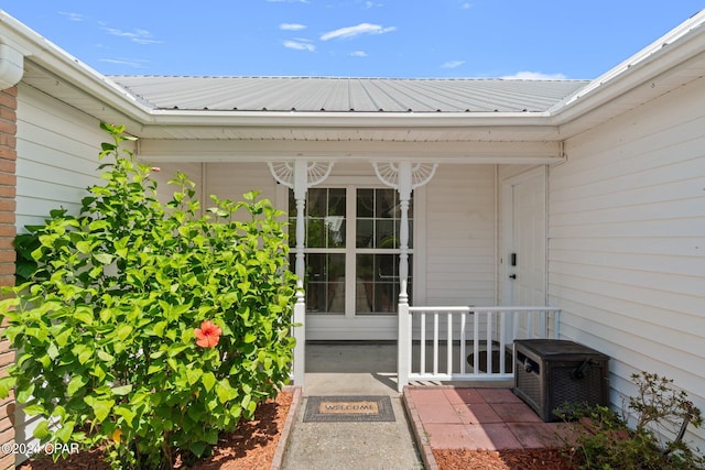 view of exterior entry featuring covered porch