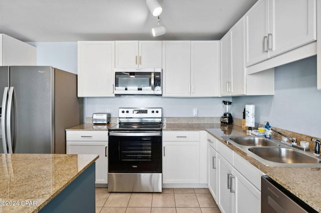 kitchen featuring white cabinets, light tile patterned flooring, stainless steel appliances, and sink