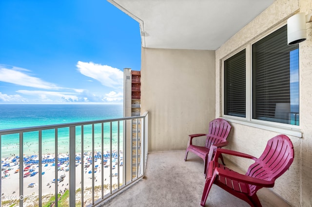 balcony featuring a view of the beach and a water view