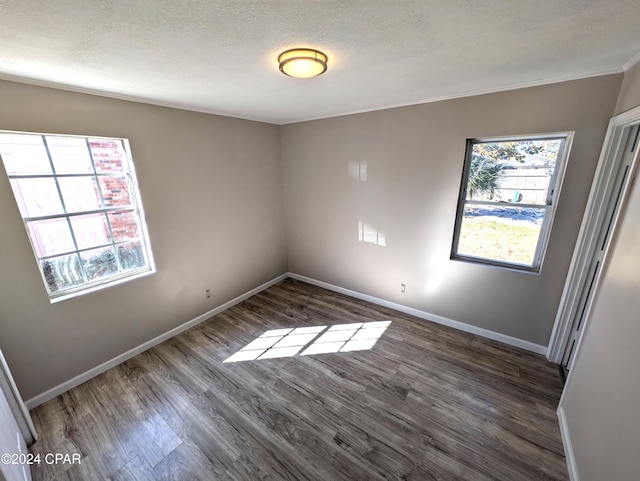 unfurnished room with dark hardwood / wood-style flooring and a textured ceiling