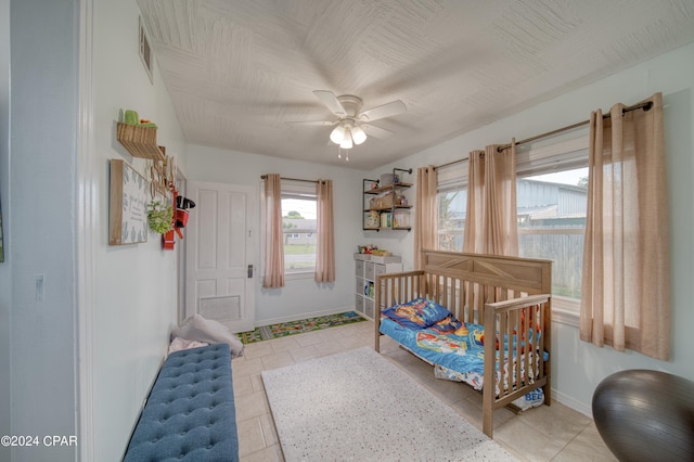 bedroom with baseboards, a ceiling fan, and light tile patterned flooring