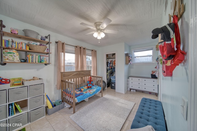 bedroom featuring ceiling fan, a closet, and light tile patterned flooring