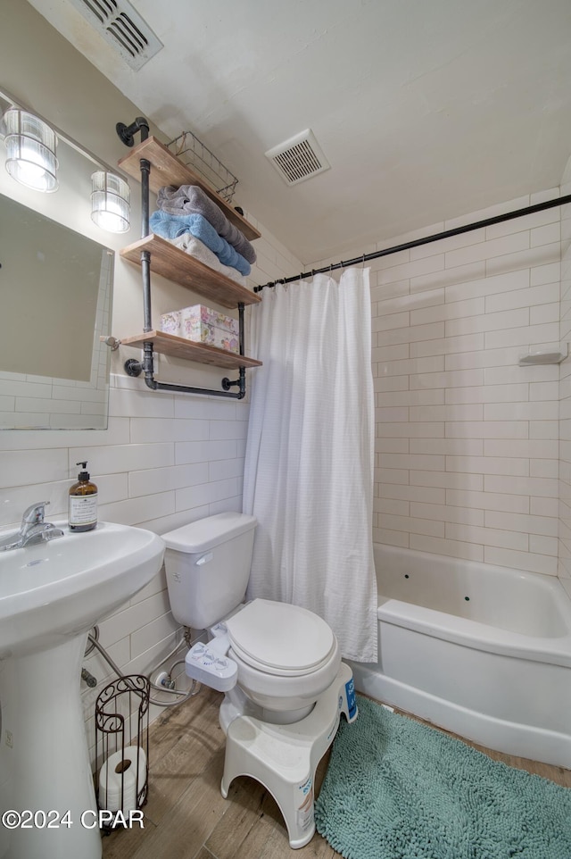 bathroom featuring toilet, shower / tub combo, visible vents, and tile walls