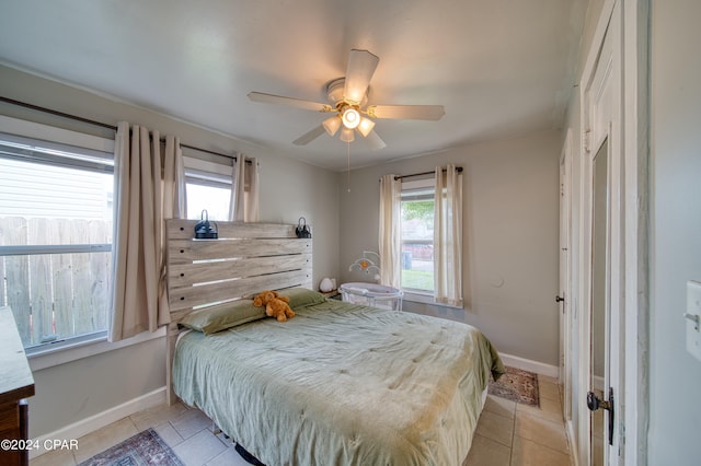 bedroom featuring light tile patterned floors, baseboards, and a ceiling fan