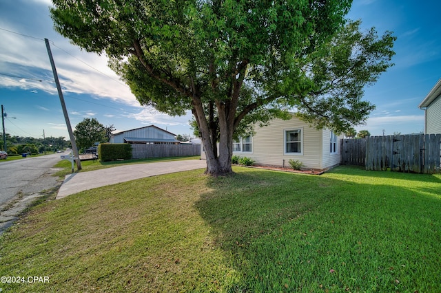 view of front of house with fence, a front lawn, and concrete driveway