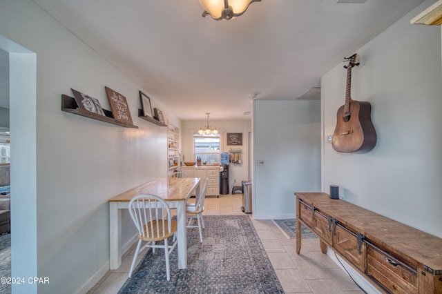 hallway with a chandelier, light tile patterned flooring, and baseboards