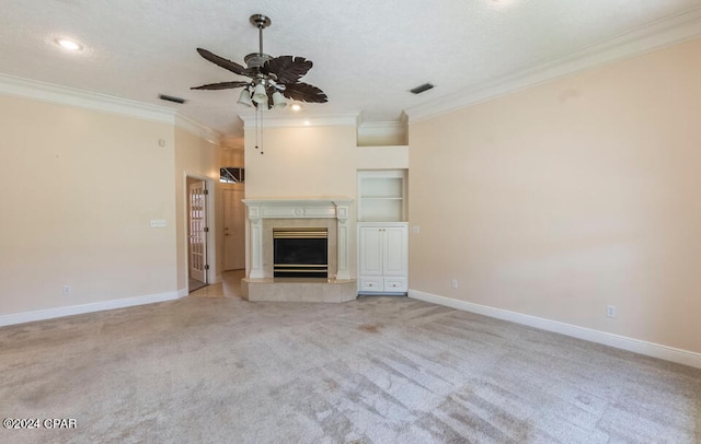 unfurnished living room featuring ornamental molding, built in shelves, a fireplace, light colored carpet, and ceiling fan