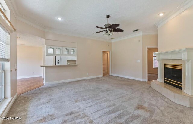 unfurnished living room featuring a wealth of natural light, light colored carpet, and a tile fireplace