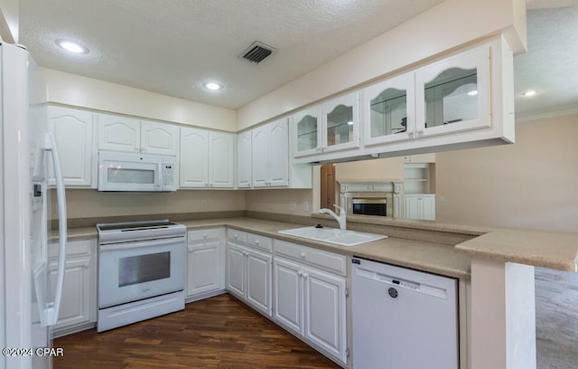 kitchen with dark wood-type flooring, white cabinetry, sink, kitchen peninsula, and white appliances