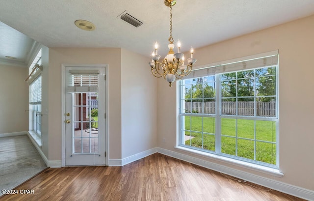 interior space with hardwood / wood-style floors, a notable chandelier, and a textured ceiling