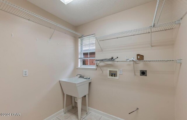 laundry room featuring a textured ceiling, electric dryer hookup, light tile patterned floors, and hookup for a washing machine