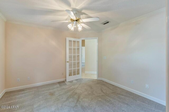 carpeted empty room with ceiling fan and crown molding