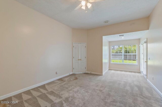 unfurnished room featuring ceiling fan and light colored carpet