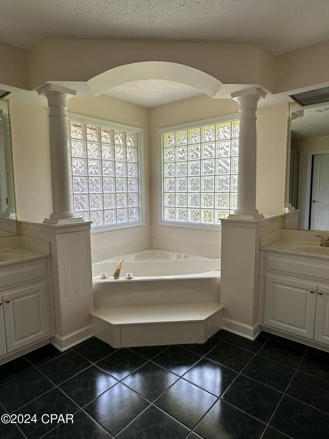 bathroom with a tub, tile patterned flooring, decorative columns, and vanity