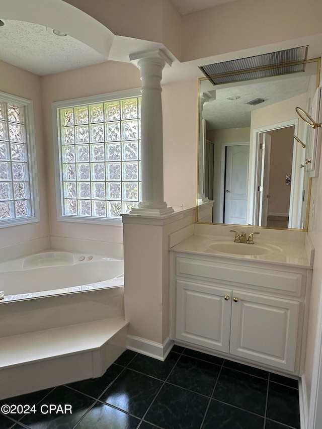 bathroom featuring tile patterned flooring, a bathing tub, vanity, and a healthy amount of sunlight