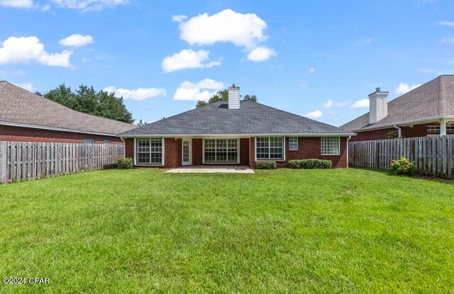 rear view of property with a patio and a lawn