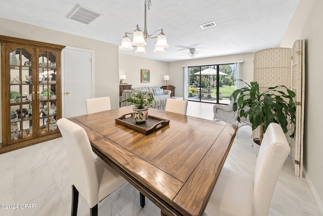 dining space with ceiling fan with notable chandelier