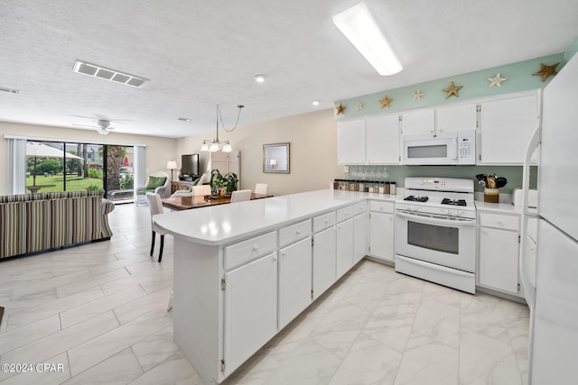 kitchen featuring white cabinets, pendant lighting, kitchen peninsula, white appliances, and ceiling fan with notable chandelier