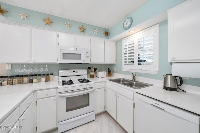 kitchen with white appliances, white cabinetry, and sink