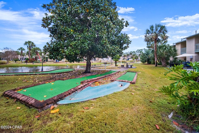 view of property's community with a lawn and a water view