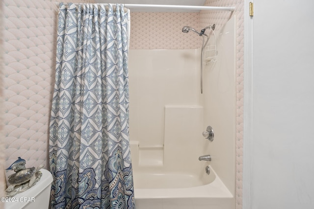 bathroom featuring shower / tub combo with curtain and toilet