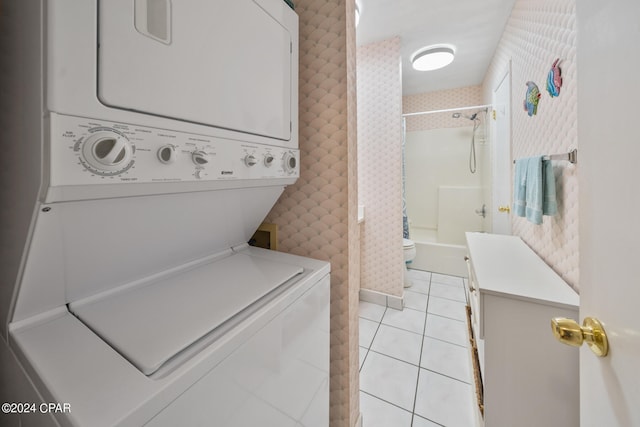 laundry room with stacked washing maching and dryer and light tile patterned floors