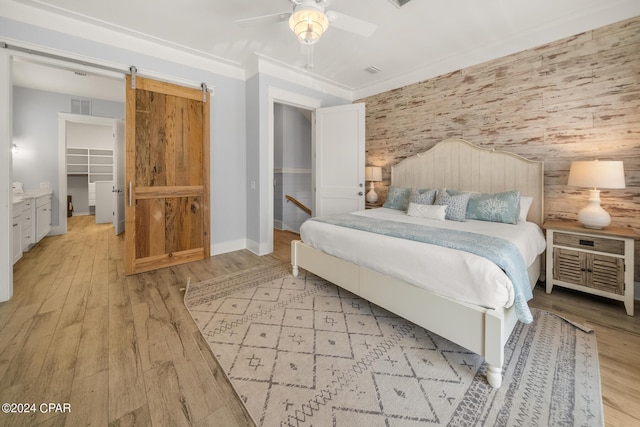 93 Emerald Cove Ln, Inlet Beach, FL 32461 - bedroom with a barn door, light wood-style flooring, visible vents, and baseboards