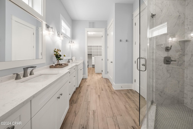 bathroom featuring vanity, hardwood / wood-style floors, and a shower with shower door