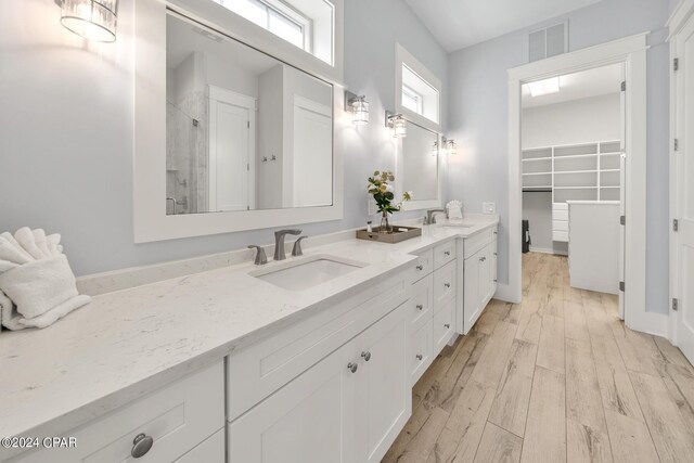 93 Emerald Cove Ln, Inlet Beach, FL 32461 - bathroom with wood finished floors, a sink, a stall shower, a walk in closet, and double vanity