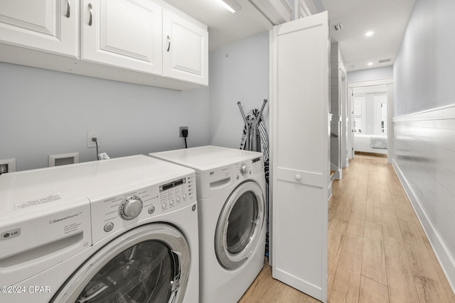 clothes washing area featuring light hardwood / wood-style flooring and washer and clothes dryer