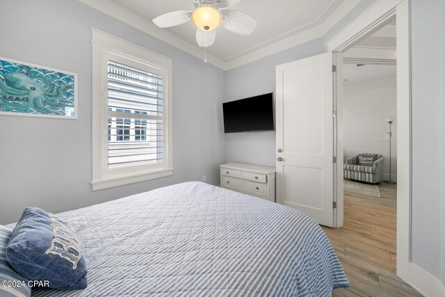 bedroom with crown molding, ceiling fan, and light wood-type flooring