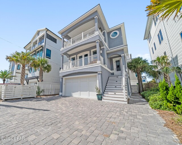 rear view of property with a garage and a balcony