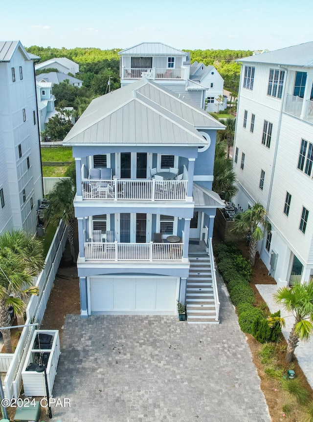 93 Emerald Cove Ln, Inlet Beach, FL 32461 - view of front facade with a standing seam roof, metal roof, a garage, stairway, and a balcony