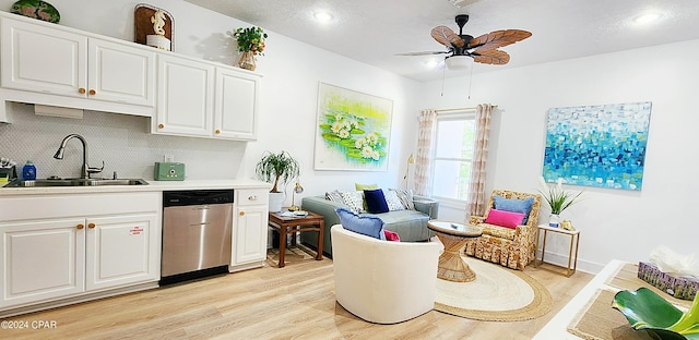 kitchen featuring light hardwood / wood-style floors, dishwasher, sink, and white cabinets