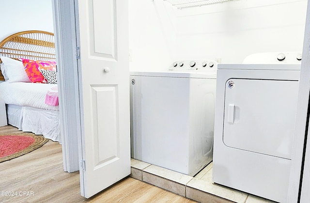 laundry room featuring light hardwood / wood-style floors and washing machine and dryer