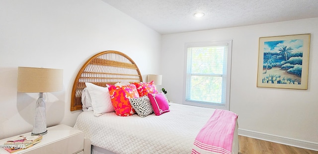 bedroom featuring a textured ceiling and hardwood / wood-style flooring