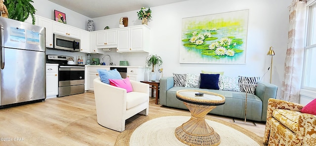 living room with sink and light hardwood / wood-style floors