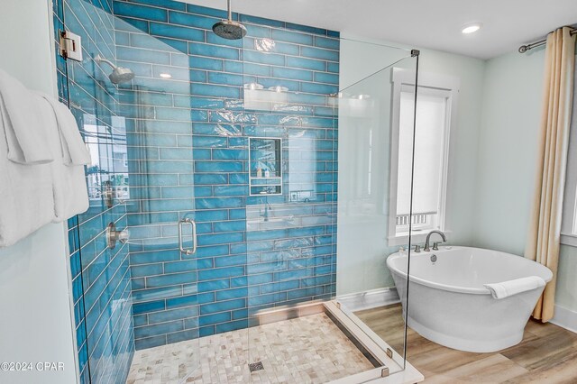 bathroom featuring hardwood / wood-style flooring and independent shower and bath