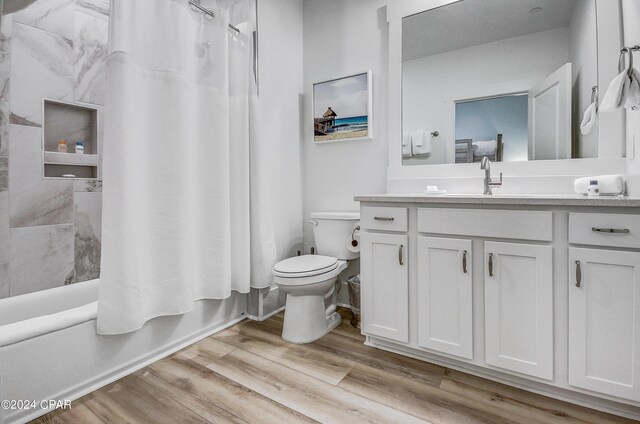 full bathroom featuring vanity, toilet, shower / tub combo, and hardwood / wood-style floors