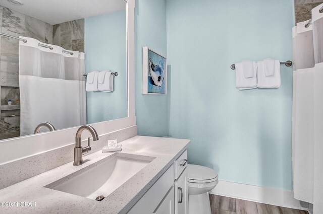 bathroom featuring toilet, vanity, and hardwood / wood-style flooring